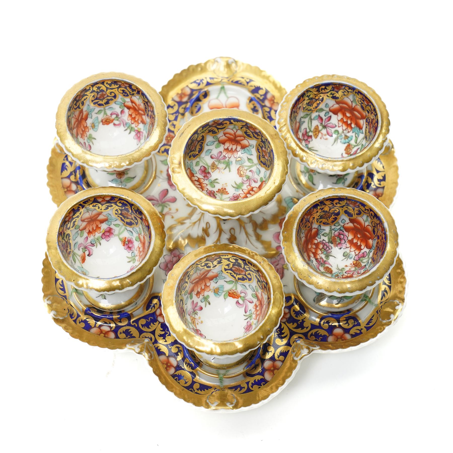 Early 19th century Chamberlain's Worcester egg stand of serpentine circular form fitted with five egg cups and decorated with flowers on a blue and gilt ground with gilt border and on paw feet D20cm. Printed mark used on the Regent body circa 1811-1820 
Provenance: property of a Nobleman