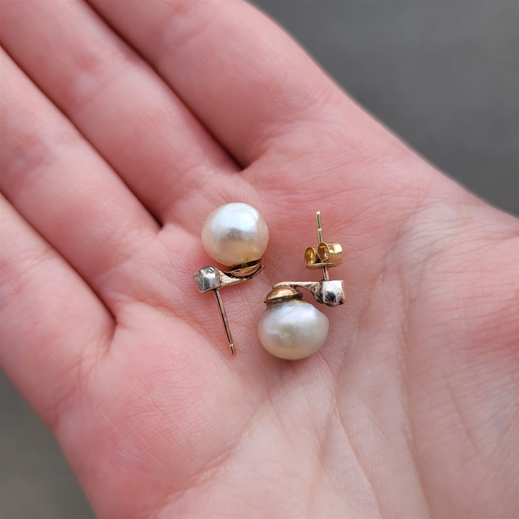 Pair of 19th / early 20th century natural saltwater pearl and diamond earrings, one stud set with a single white / cream pearl, the other with a white / grey / cream pearl, each suspending from a single old cut diamond, total pearl weight approx 4.30 carat