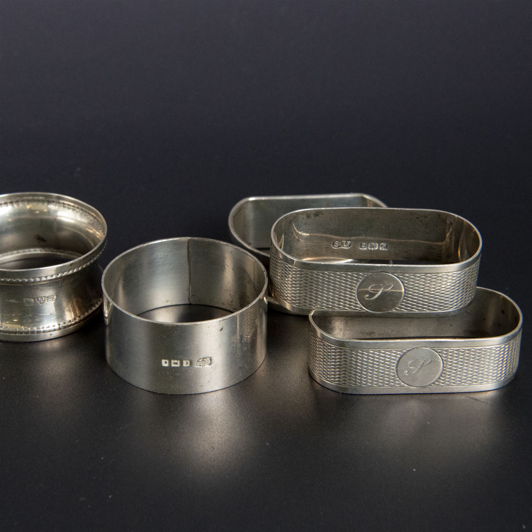Five silver napkin rings, including pair of 1930s oval examples, with engine turned decoration with engraved initial, together with a collection of silver flatware, including Norwegian spoon, pair of Fiddle pattern mustard spoons, five seal top coffee spoons, etc, all stamped or hallmarked