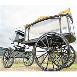 Victorian Glass Hearse

A black painted four wheeled horse drawn glass hearse with extensively glazed coffin compartment, etched glass side and end panels, decorative gilt cresting, gilt column capitals, white painted interior bier deck, metal coffin rails with cross finials, rear glazed access doors, external coachman's box seat for two, wooden spoked wheels the wheel hubs stamped 'The Economic Funeral Co', leaf spring suspension, underbody turntable steering and pole for driving with a pair of horses. The hearse has decorative painted lining throughout and an ornate black and gilt body with curved glass panels to the sides and rear.

Features

• Extensively glazed coffin compartment
• Etched glass side and end panels
• Decorative gilt cresting
• Gilt column capitals
• White painted interior bier deck
• Metal coffin rails with cross finials
• Rear glazed access doors
• External coachman's box seat
• Wooden spoked wheels
• Leaf spring suspension
• Underbody turntable steering
• Pole for driving with a pair of horses
• Decorative painted lining

Dimensions:
Overall length: 406 cm
Body length: 250 cm
Overall width: 190 cm
Body width: 115 cm
Height: 228 cm

Wheel Diameters:
Front wheels: 102 cm
Rear wheels: 133 cm

Seating

Coachman's box seat: 2