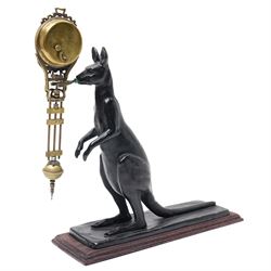  20th century-8-day Marsupial mystery clock with a cast brass patinated model of a standing Kangaroo on a wooden base, with a swinging compound pendulum resting on two steel pivots, white dial with Arabic numerals, minute track and steel spade hands, wound and set from the rear.