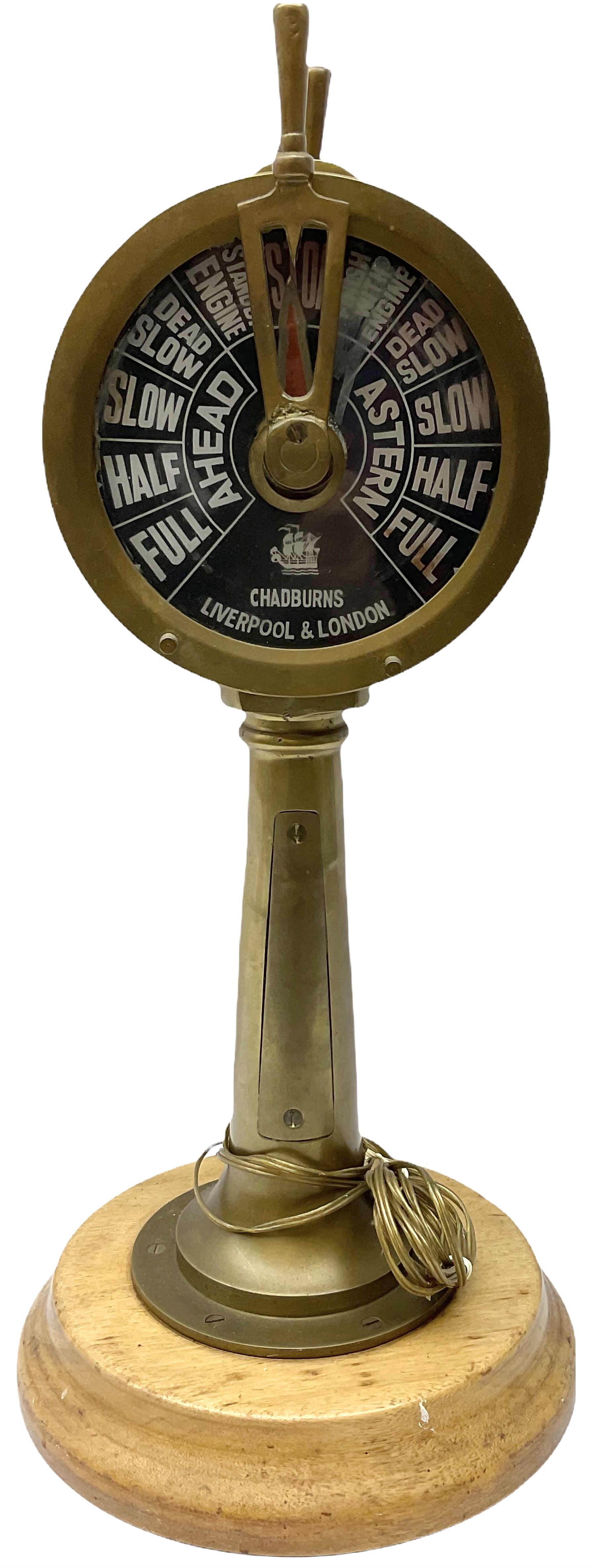 Early 20th century, illuminating brass ship's telegraph by Chadburns of Liverpool and London, on a circular wooden plinth, H55cm