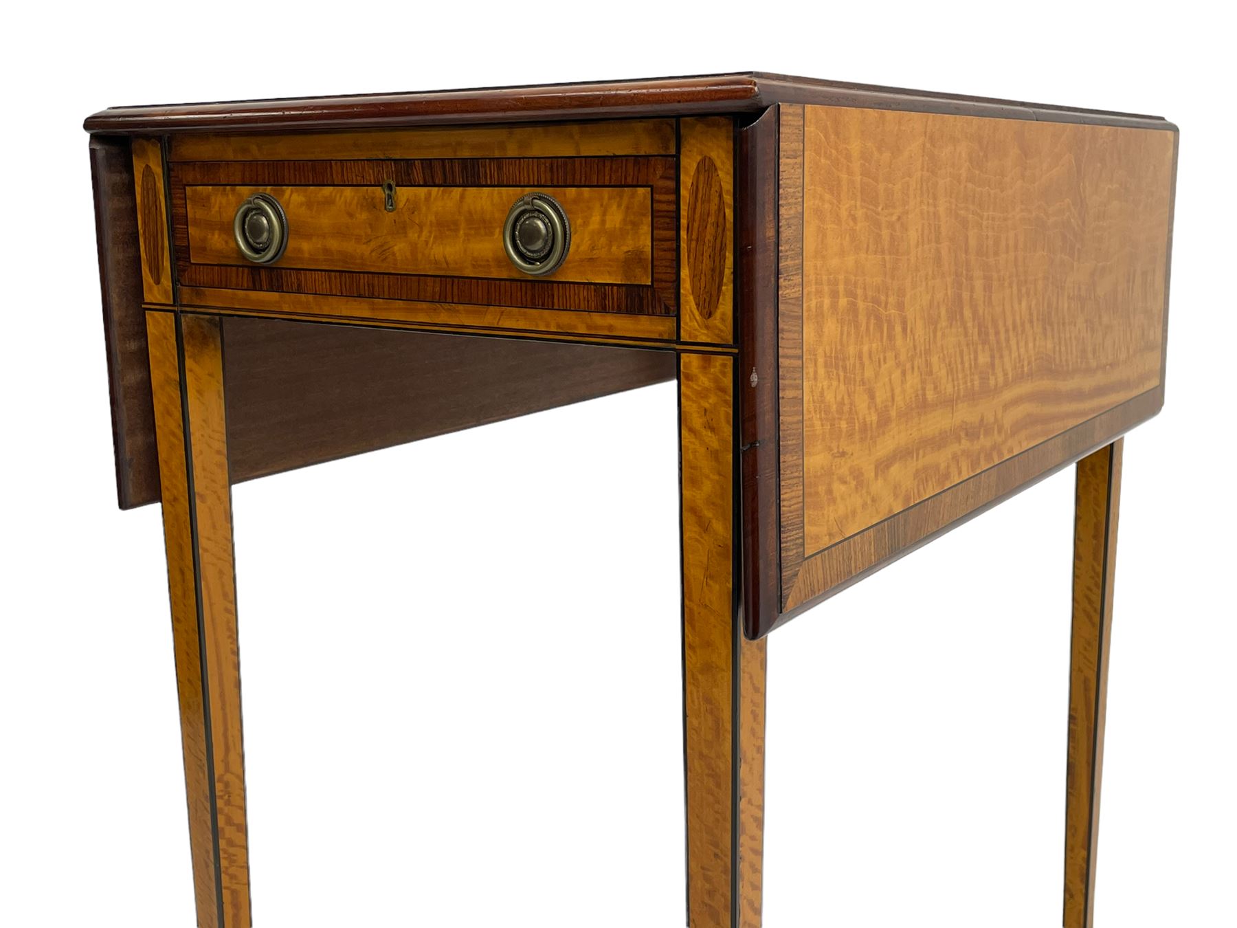 Mid-to-late 20th century Sheraton style satinwood Pembroke table, the drop leaf top with segmented veneers and central oval panel with ebony stringing, crossbanded in rosewood and with edge moulding, single short drawer to one end and faux drawer to other, square tapering supports