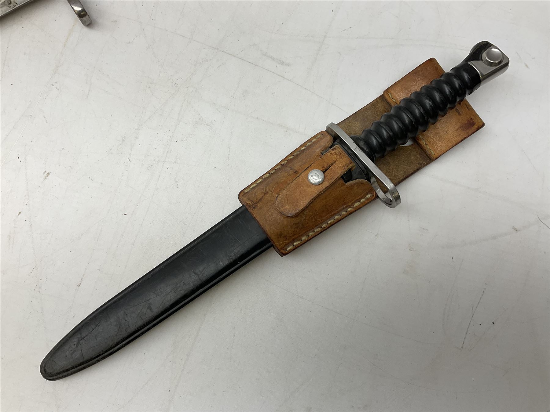 Schmidt-Rubin Model 1918 bayonet, the 30cm steel blade marked Elsener Schwyz, cross-piece numbered 813558; in steel scabbard with leather frog stamped E. Banga Sattler Selzac 67 L45.5cm overall; and Swiss Model 1957 SIG rifle bayonet by Wenger; in plastic scabbard with leather frog stamped E. Walty Sattlerei Baretswil 84 (2)