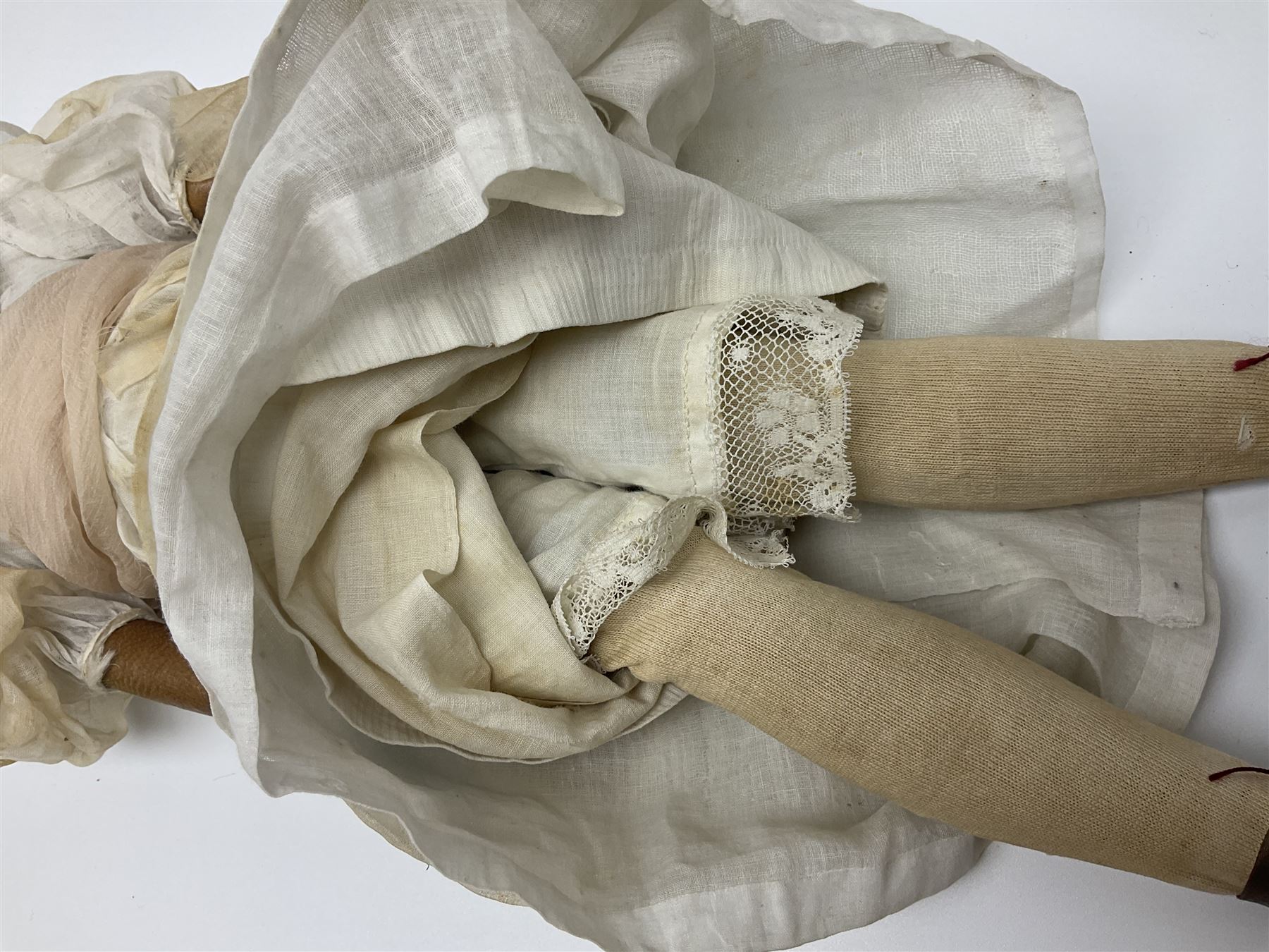 Victorian wax shoulder head doll with pale complexion, applied hair, inset glass eyes and fabric covered jointed body with kid leather lower arms; white linen dress and undergarments H50cm