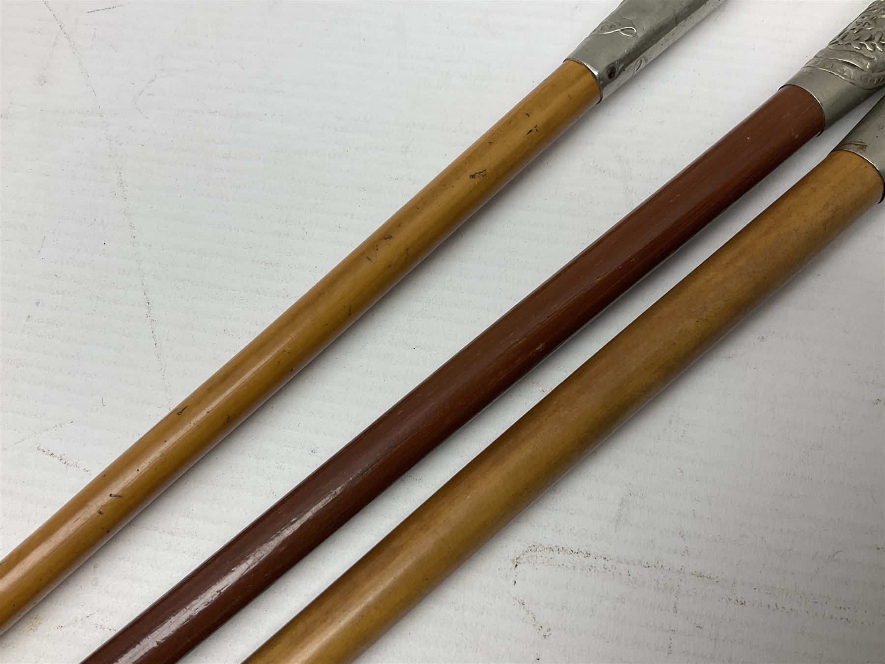 Three malacca cane swagger sticks - Duke of York's Royal military School L68cm; RAMC; and another embossed with a lion to the terminal (3)