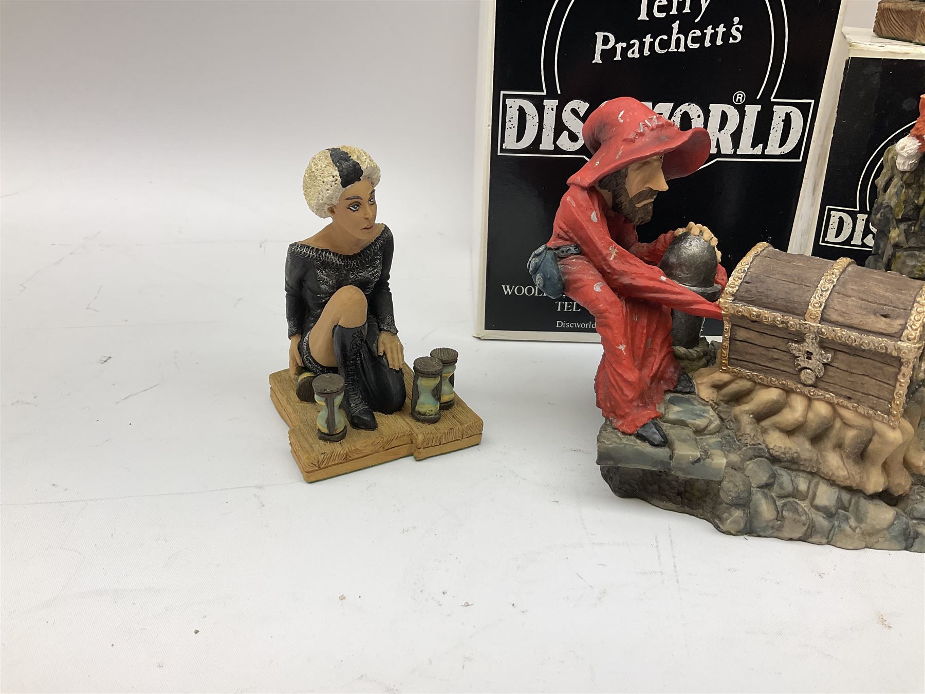 Terry Pratchett Discworld figures, designed by Clarecraft, comprising Rincewind and Luggage bookend DW41, Imp Y Celyn, DW81, C.M.O.T Dibbler, DW35, Rincewind, DW01 and Susan Sto Helit, boxed, DW77