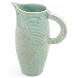 Susie Cooper pottery jug, the green glazed body with ring turned and dimpled decoration, inscribed 'Susie Cooper, England' to base, H23cm; together with two similar art deco pottery jugs with similar decoration, by Price Brothers and Ditmar Urbach, larger H21cm (3)
