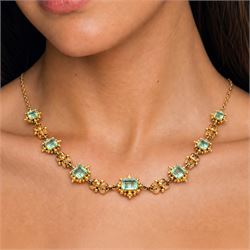 19th century gold emerald necklace, seven closed back octagonal cut and square cut emeralds, surrounded by a fancy bead setting, each spaced by a pierced scroll and bead design link, to a cable link chain necklace, with The Gem & Pearl Laboratory report