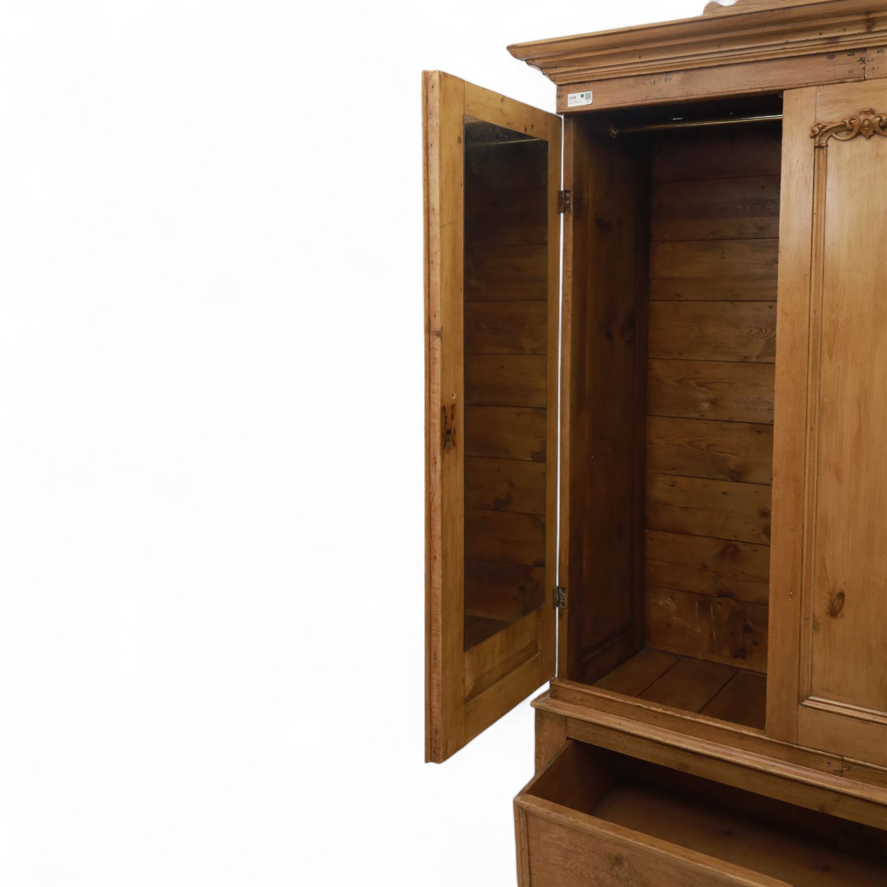 Late 19th century pine wardrobe, with stepped cornice over triple panelled doors, applied foliate carvings to outer panels, raised over a separate pine plinth drawer with moulded facia and twin glass pulls
