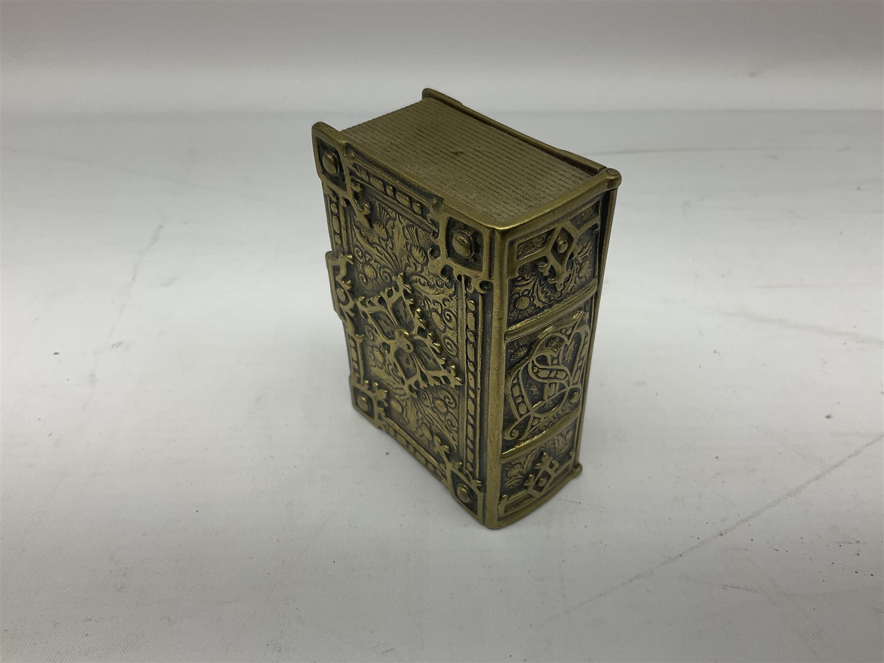 Collection of victorian and later brass desk accessories, to include a letter holder with cherub design, ink well of square form with hinged lid, brass table bell, brass casket with relief decoration, etc  