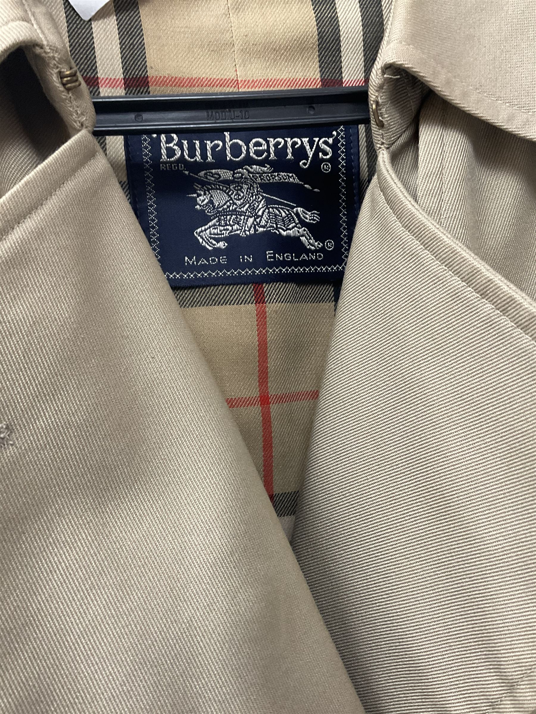 A ladies Burberry trench coat, with waist belt and check lining, no size label, measures approximately arm pit to arm pit L51cm, H117cm