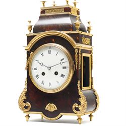 French-late 19th century brown stained 8-day faux Tortoise shell and ormolu mounted mantle clock, rectangular case with glazed side panels and shaped pediment with matching finials, convex enamel dial with Roman numerals, minute track and steel moon hands within a cast brass glazed dial bezel,
twin barrel movement with rack striking, striking the hours and half hour on a coiled gong. With pendulum and key.