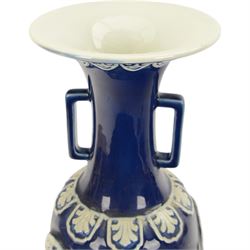 Chinses twin handled blue and white vase, decorated in relief with dragons amongst clouds upon a blue ground, H58cm 