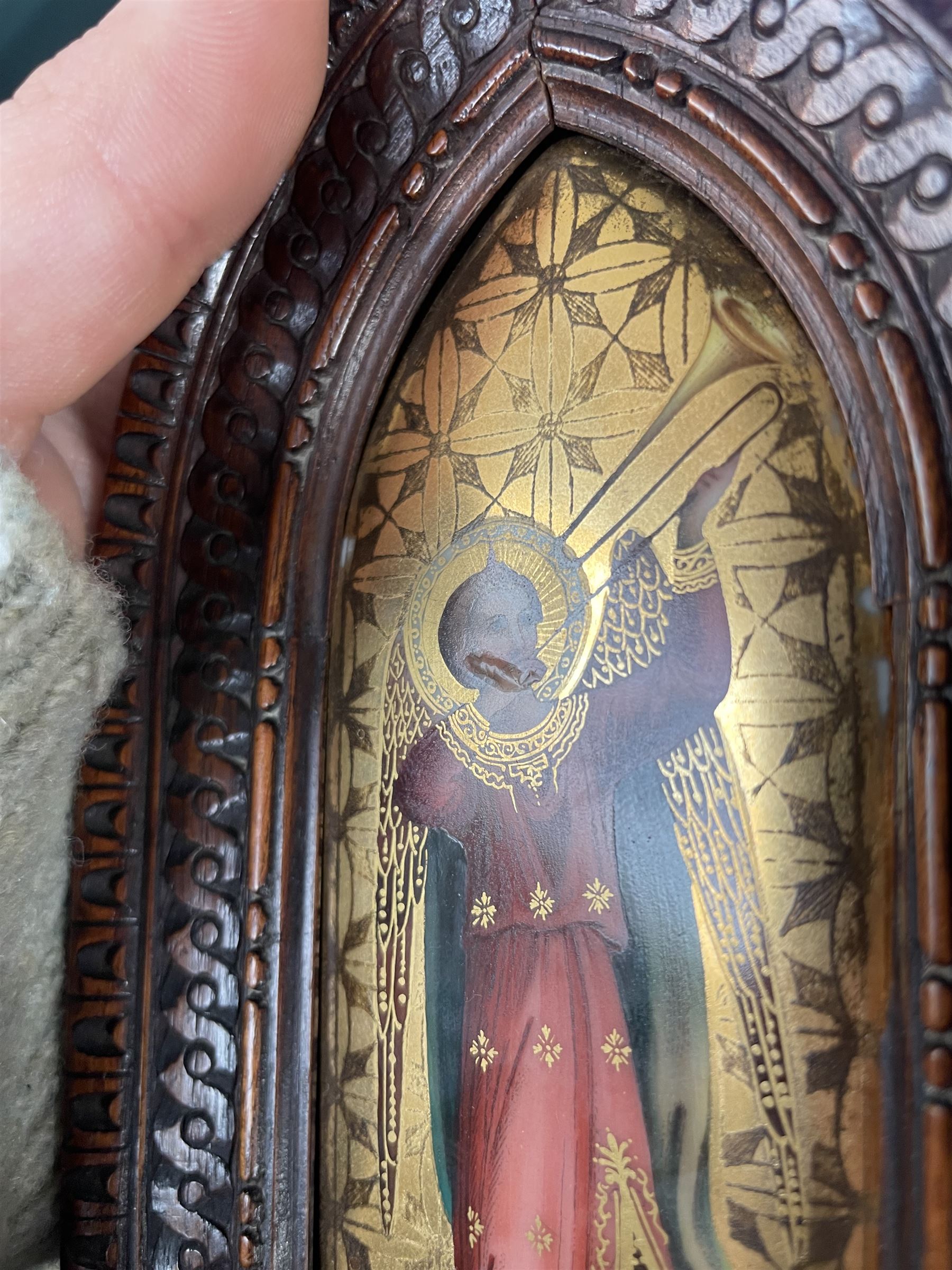 Pair of early 20th century continental painted porcelain religious icon plaques, depicting two angels playing a violin and a sackbut, heightened in gilt, within carved gothic frames, H15cm; together with a camphor wood box with carved decoration, W28cm (3)