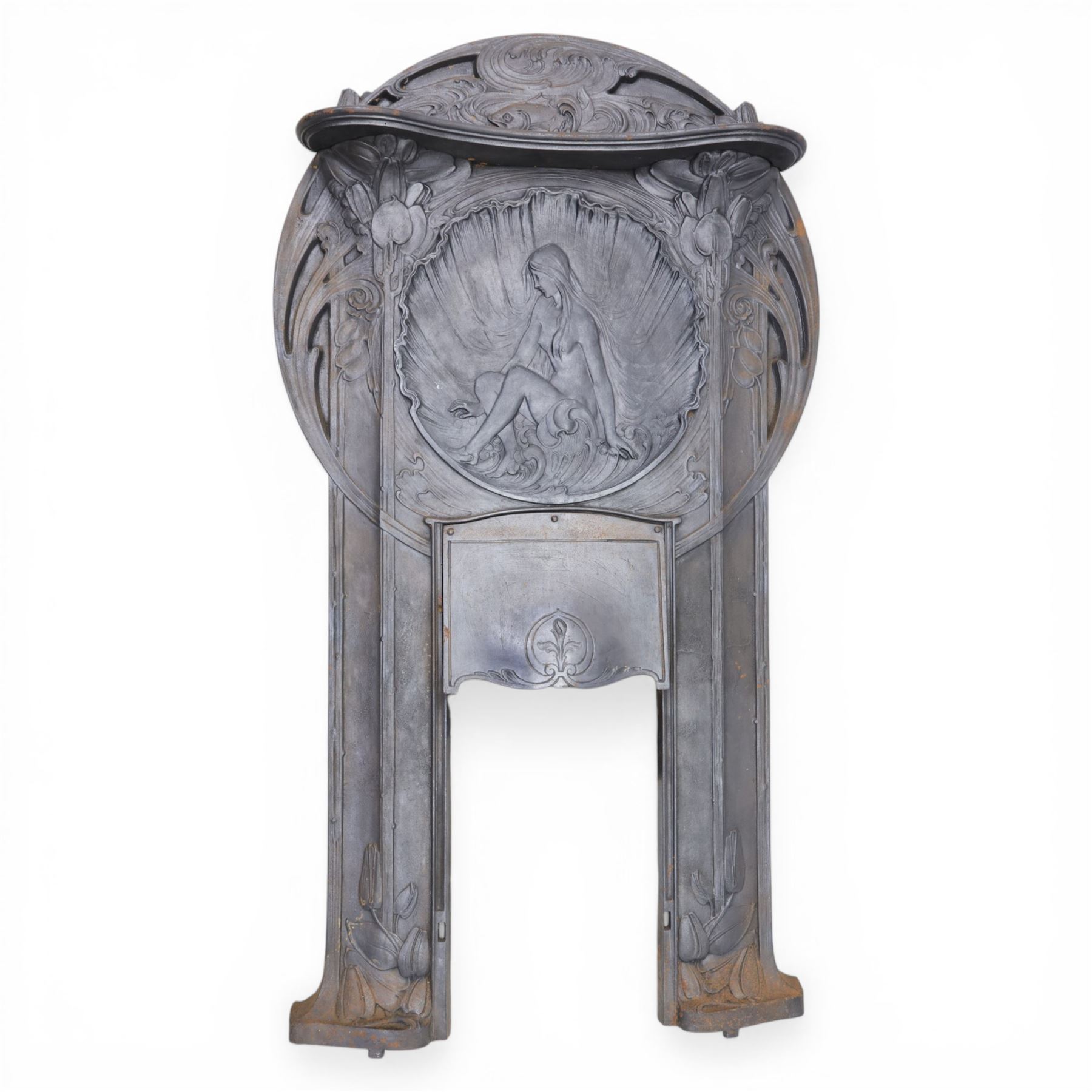 Art Nouveau cast iron fireplace, shaped hood with scrolling foliate crest, relief cast panel of female figure seated within shell form amidst wave motifs, uprights cast with foliate designs