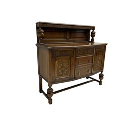 Early 20th century oak sideboard, the raised panelled back supports by two turned and carved balusters, shaped front with moulded top, fitted with three drawers and two cupboards, decorated with blind fretwork strapping, turned and carved baluster feet connected by moulded stretchers