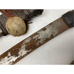 Mandingo sword, the 63cm plain curving steel blade marked with a horses head and the initials G.S.; leather covered grip with metal ribbed spherical pommel; in decorative leather leaf scabbard mounted with tassels and roundels L84cm overall; and a North African flyssa sword in poor condition with wooden scabbard (2)