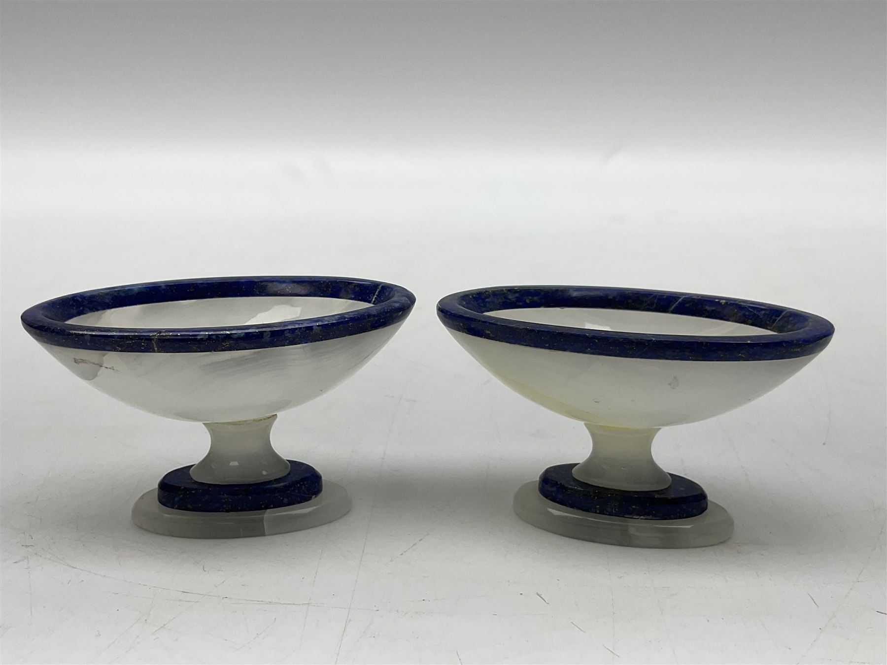 Pair of lapis lazuli and agate open salts, of navette form, upon a stepped oval pedestal foot, H5cm, L8cm