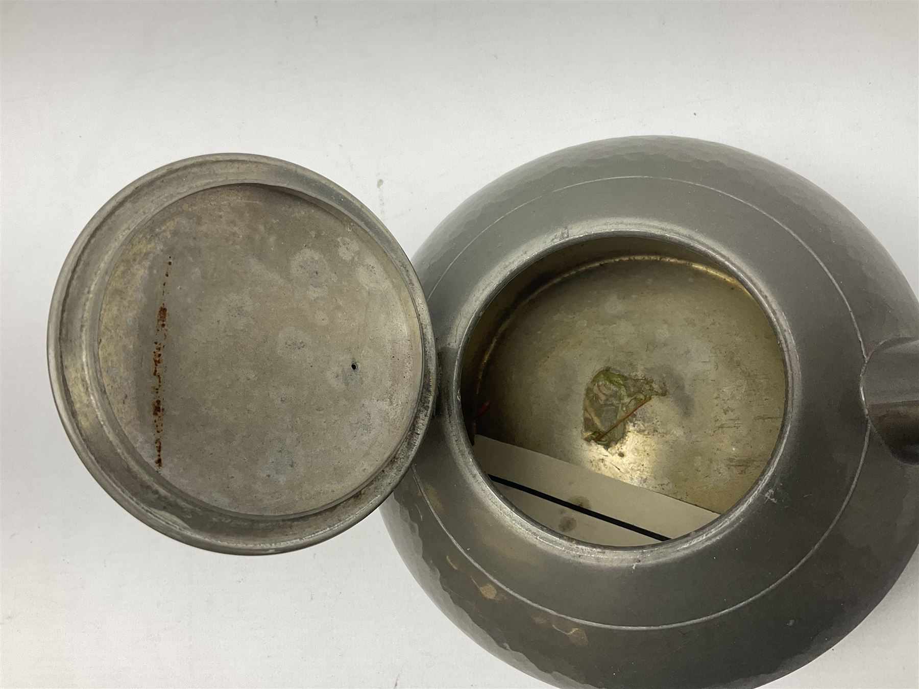 Liberty & Co Tudric pewter three piece tea service, comprising teapot with woven reed handle, twin handled open sucrier, and milk jug, each of squat form with planished finish, each impressed beneath Tudric Pewter Ware 01537 Made in England, together with a matched unmarked tray