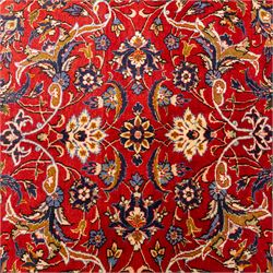 Central Persian Markazi Mahal hand-knotted carpet, terracotta red field, with an all-over scrolling vine design issuing with palmettes, rosettes, and serrated leaves, linked by ivory vinery, deep cobalt blue main border with floral ornamentation, flanked  by multiple guard stripes of repeating geometric motifs, with cotton fringe ends