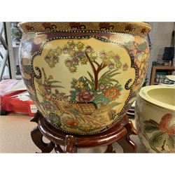 20th century Oriental fish bowl jardinière, decorated with reserves of birds amongst flowers, on wooden stand, fish bowl H29cm D36.5cm, together with another smaller example 
