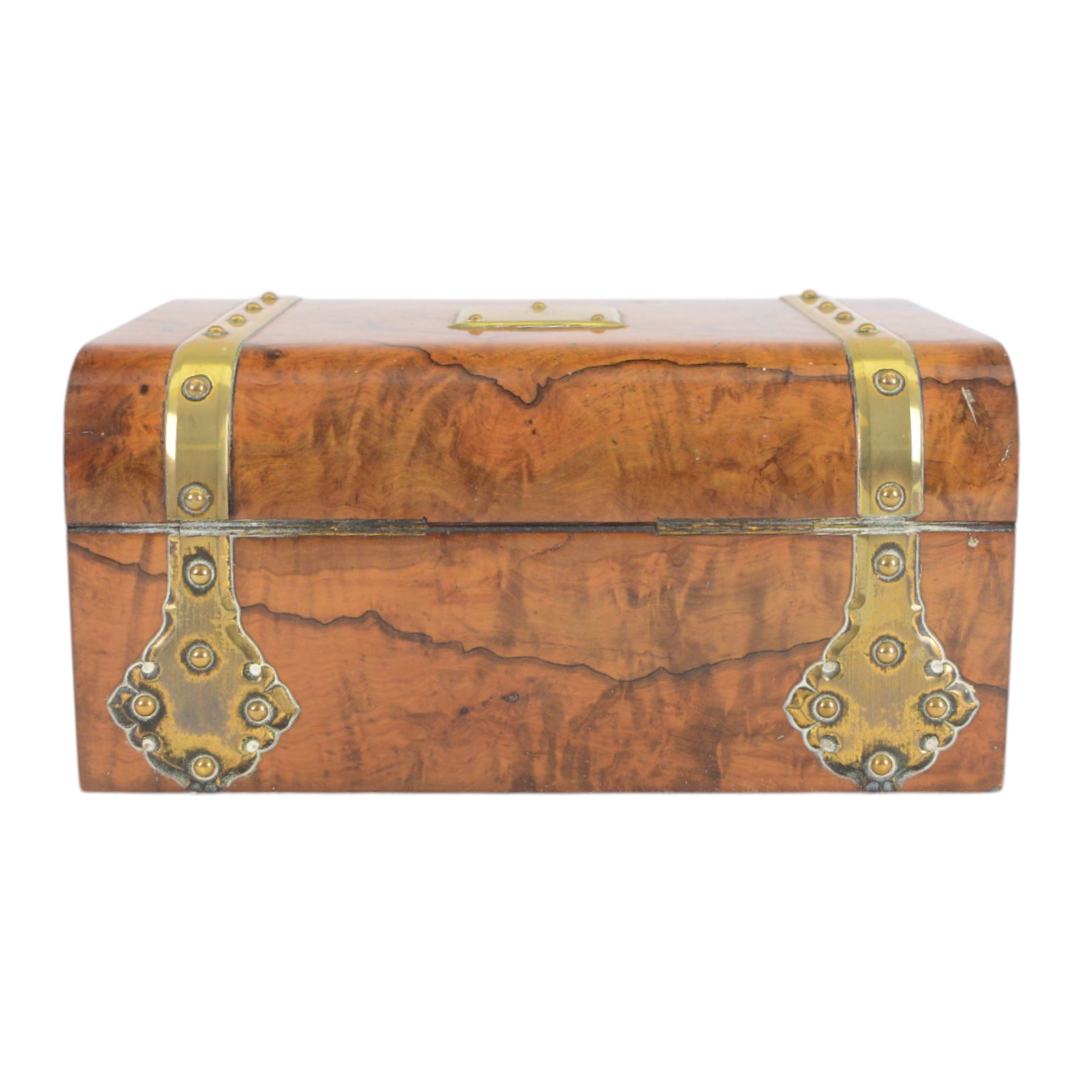 19th century walnut and brass bound games compendium box, painted to enhance the grain, of rectangular form, the hinged opening cover with rounded sides, central brass cartouche with engraved lion crest, and brass riveted straps, opening to reveal a red leather and blue silk lined compartmented interior, with fold-down games board, and lift-out tray containing playing cards, ebony turned dice towers, white and red stained bone draughts, and chess pieces, ivory dice, and ivory and ebony whist markers, and brass bezique board, cribbage board and markers, H15cm W32cm D24cm
This lot has been registered for sale under Section 10 of the APHA Ivory Act