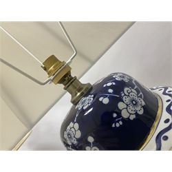 Pair of blue and white table lamps, each of baluster form, decorated with prunus blossom, within stylised borders, raised upon circular gilt base, excluding fittings H48cm
