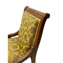 Late Victorian oak nursing chair, moulded frame with flower head carved roundels, upholstered in floral pattern fabric, on turned front feet with brass and ceramic castors 