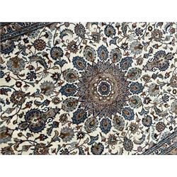 Persian Kashan ivory ground rug, the central medallion surrounded by an arrangement of palmettes united by scrolling leafy branches, peach ground main border decorated with trailing leaf and stylised plant motifs, floral pattern guard stripes 