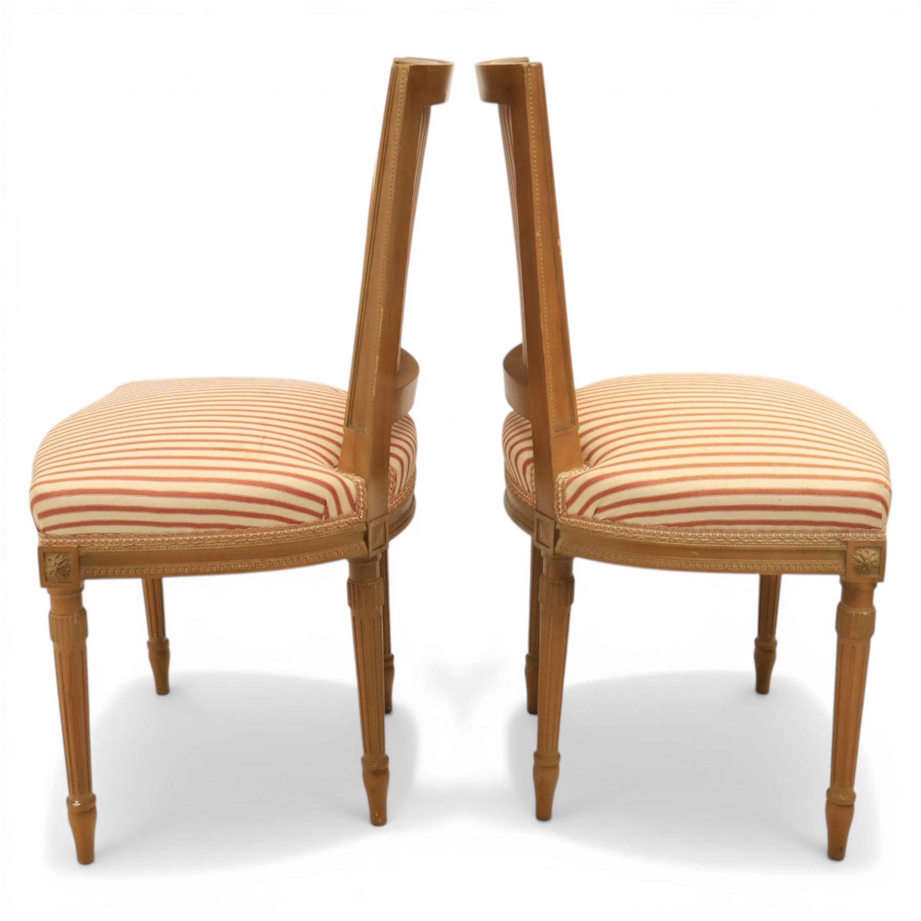 20th century Louis XVI style beech salon suite, comprising settee and four chairs, the settee with shaped rectangular back and upholstered arms over a shaped seat, the chairs with rectangular backs and overstuffed seats, each upholstered in striped fabric with close-nailed borders, upon fluted tapering supports headed by carved paterae, terminating in toupie feet, chairs H89cm W47cm