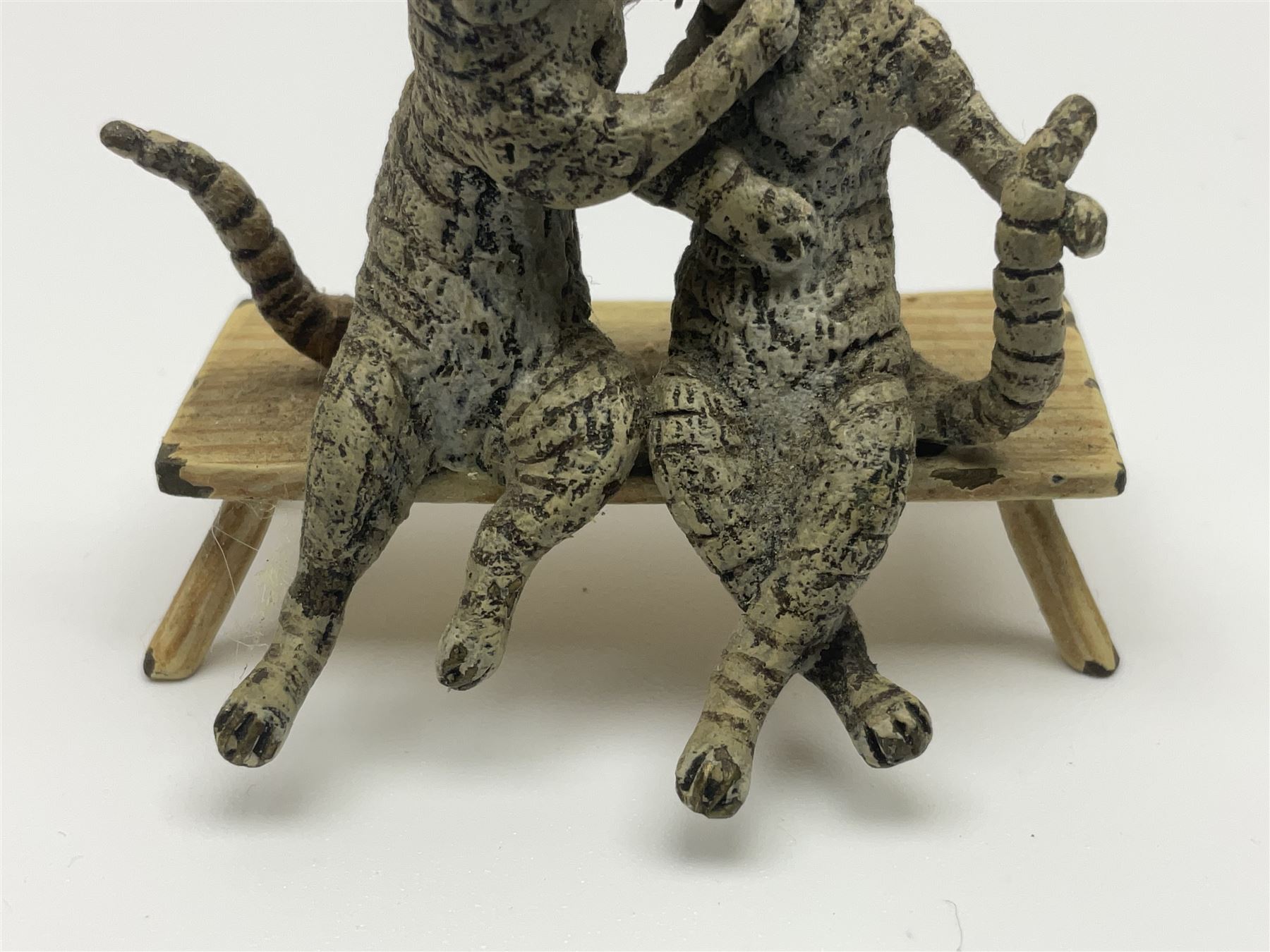 After Bergmann, two cold painted bronze figures, the first modelled as two cats on a bench hugging, the second a cat caning a kitten