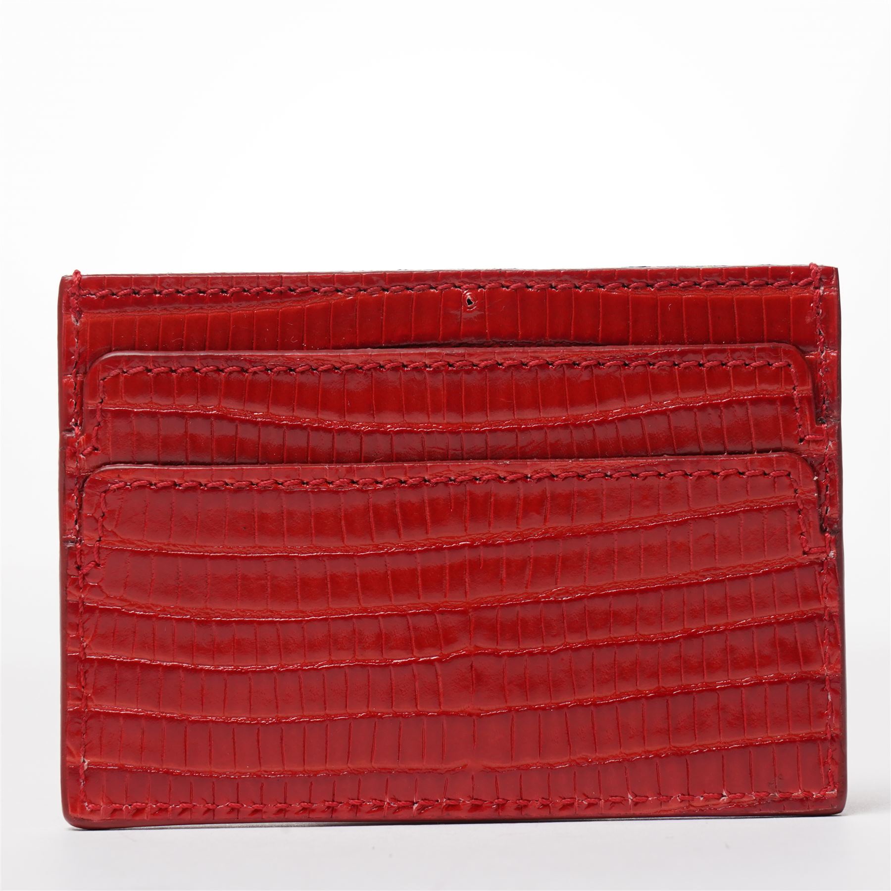 Alexander McQueen - a leather card holder in red lizard-effect leather, with multiple card slots and silver-tone skull motif to the front, unused, 7cm x 10cm