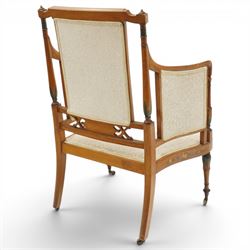 Pair of Victorian Sheraton Revival painted satinwood armchairs, the cresting rail painted with trailing floral bouquets flanked by illusion arcade motifs, over a cameo back and sides with acanthus painted swell-turned uprights, the lower back rail decorated with a bird scene and flanking pierced foliate design, upholstered in ivory fabric, raised on turned supports with further acanthus leaf paintwork, terminating to brass castors