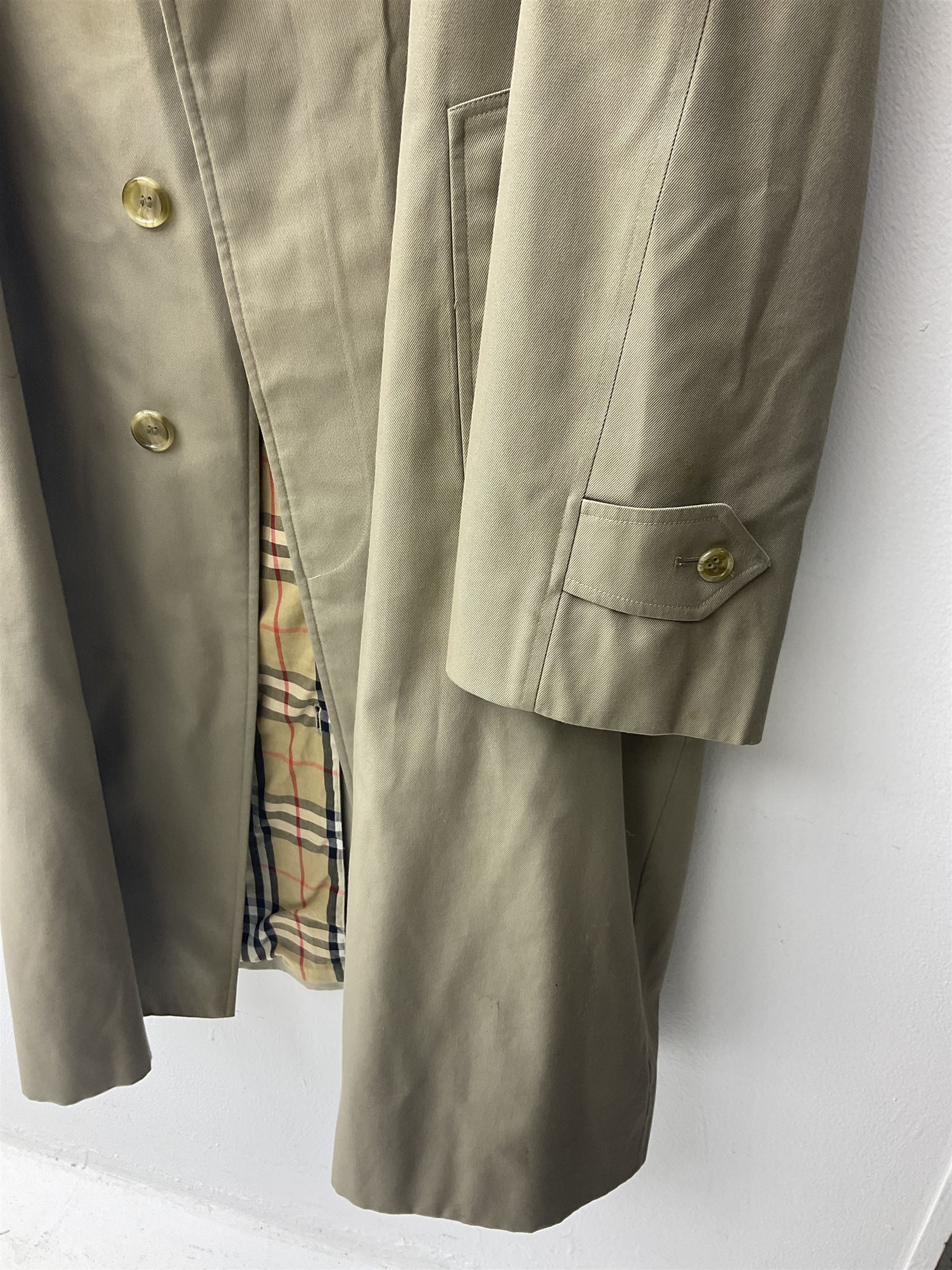 Ladies Burberry double breasted trench coat, with belt and detachable woollen gilet, in traditional cream colour with Burberry check lining, together with a gentlemans Burberry single breasted trench coat, both L112cm