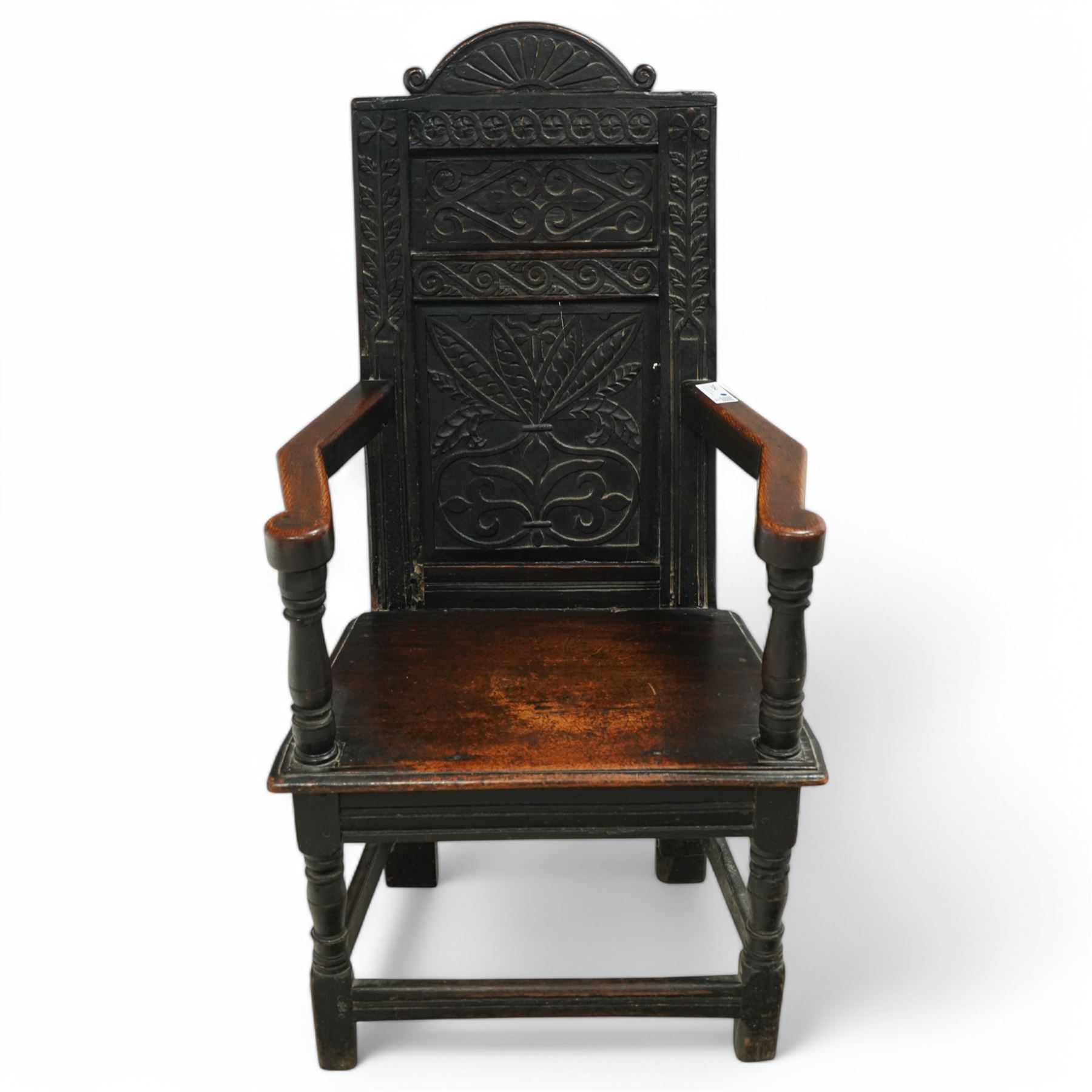 17th century and later carved oak Wainscot chair, the panelled back decorated with carved foliage and scrolls, the frame decorated with trailing guilloche and foliate motifs, moulded seat over turned supports united by stretchers 