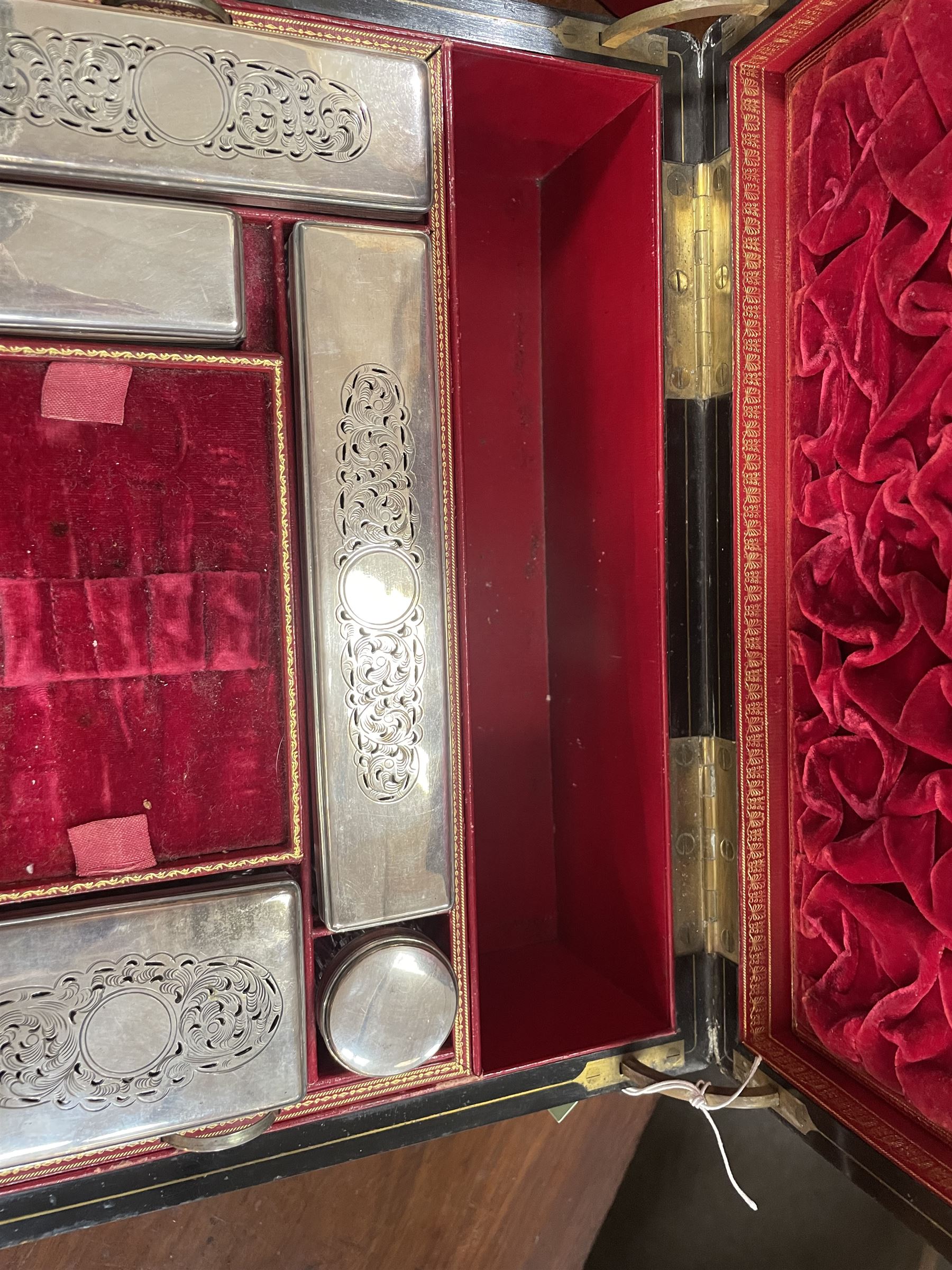  Victorian brass inlaid rosewood dressing table box, retailed by F.L. Hausburg, Liverpool, the lid centred by a brass cartouche, opening to reveal letter store to lid underside, above a fitted interior, with ten mounted cut glass jars, bottles and manicure set, within lift out leather trays, above jewellery drawer, with key, H17cm D24cm