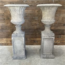 Pair of large Georgian design cast stone garden urns, egg and dart border, tapering column on square base, raised on square column