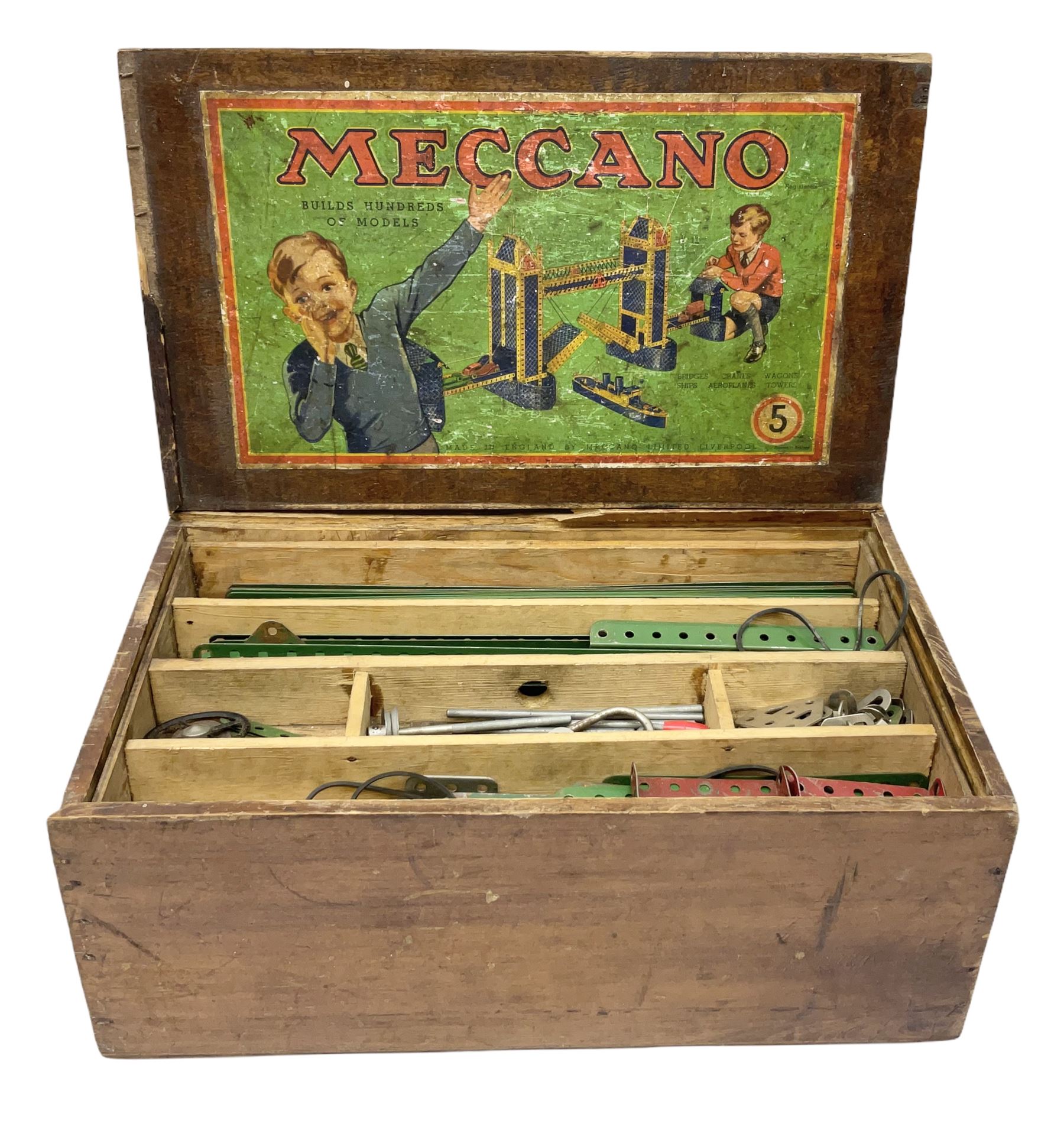 Meccano - wooden box with Set No.5 label to sliding lid, containing two lift-out trays and bottom layer of predominantly red and green sections, wheels, pulleys, rods, tyres etc, carrying handles to either end, L36cm D22.5cm H13.5cm