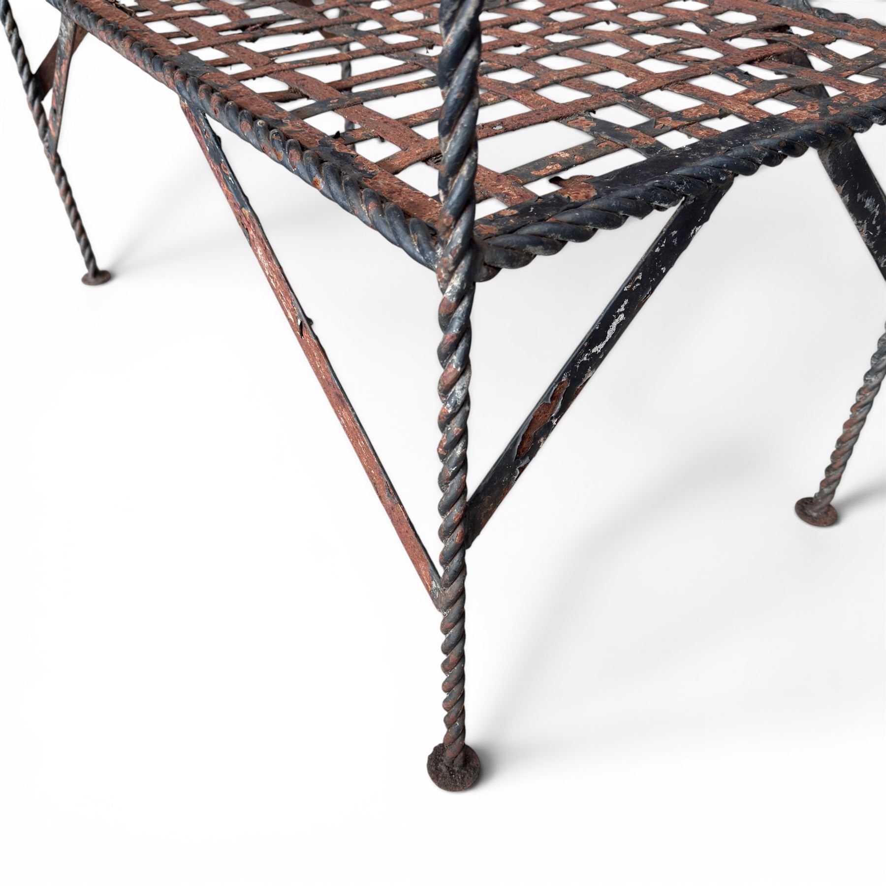 Victorian design wrought iron garden bench, with asymmetrical rope-twist frame, arched back and sides over out-swept arm terminals with ball finials, flanking a lattice seat, in antique black-painted weathered finish
