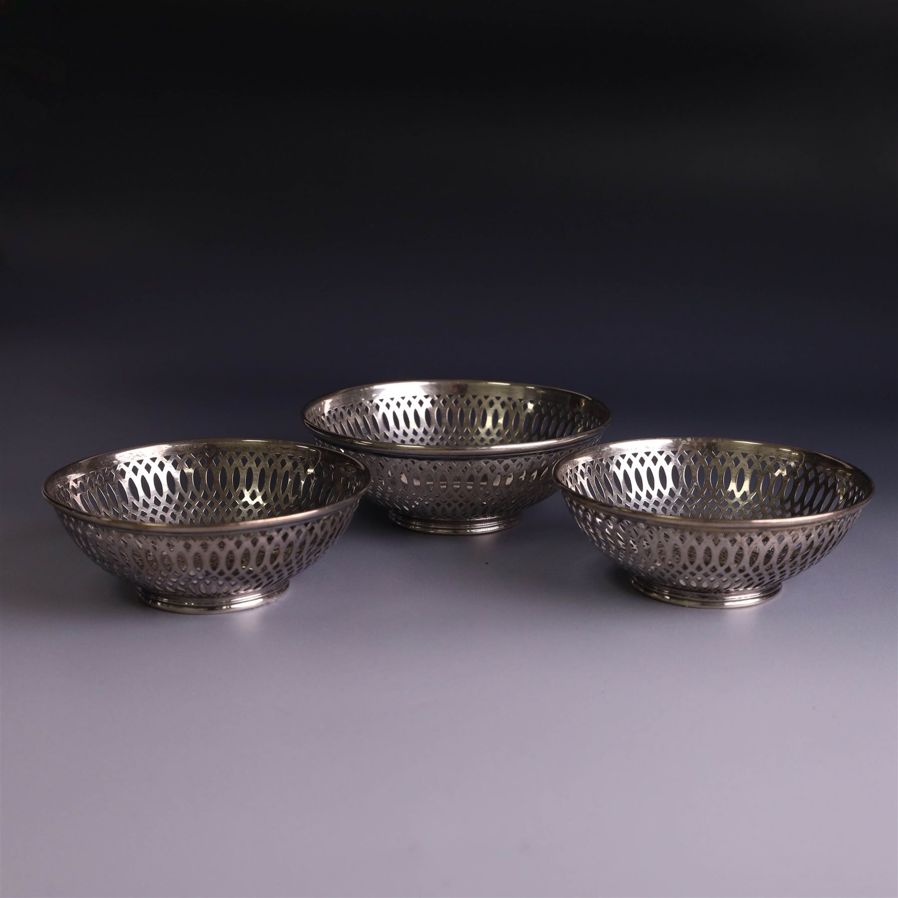Three 1930s silver bon bon dishes, comprising pair and one larger example, each of circular form with pierced latticework sides, hallmarked Maxfield & Sons Ltd, Sheffield 1936, largest D12cm