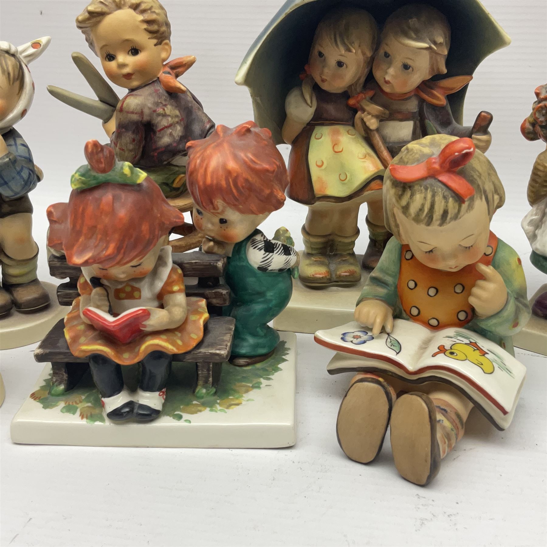 Sixteen Goebel Hummel figures, including Charlot A Young Man's Fancy, Stormy Weather and Bookworm, all with impressed and printed marks beneath