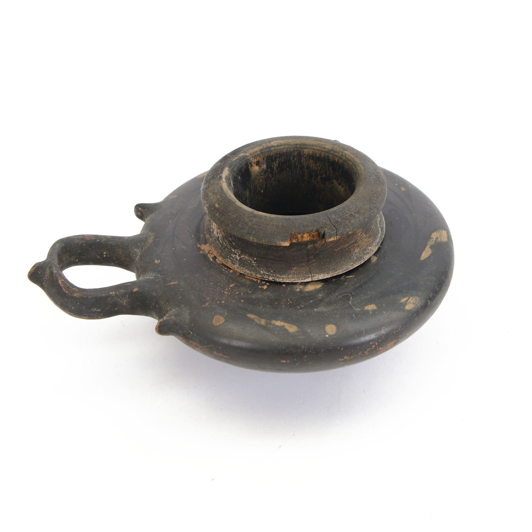 Etruscan terracotta oil lamp, with black glaze, flat loop handle and laurel leaf border, the opening with later turned wooden collar, signed to base 'repaired by one James Naysmith 1887', H7cm 