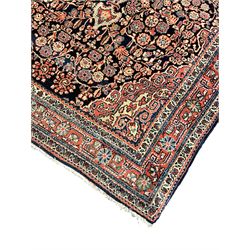 Persian indigo ground rug, the field decorated with intricate interlaced foliage branches and small flower heads, shaped floral design central medallion, the border decorated with scrolling branch and flower heads within guard bands 