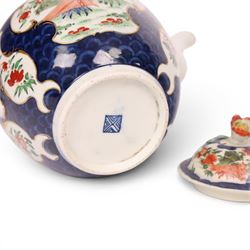 18th century Worcester teapot, circa 1763-70, of globular form, painted with shaped panels of chrysanthemums and banded hedges on a blue scale ground, cover with flower finial, mark beneath, H15cm