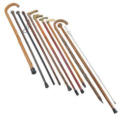 Collection of walking sticks, including two silver topped examples, hallmarked