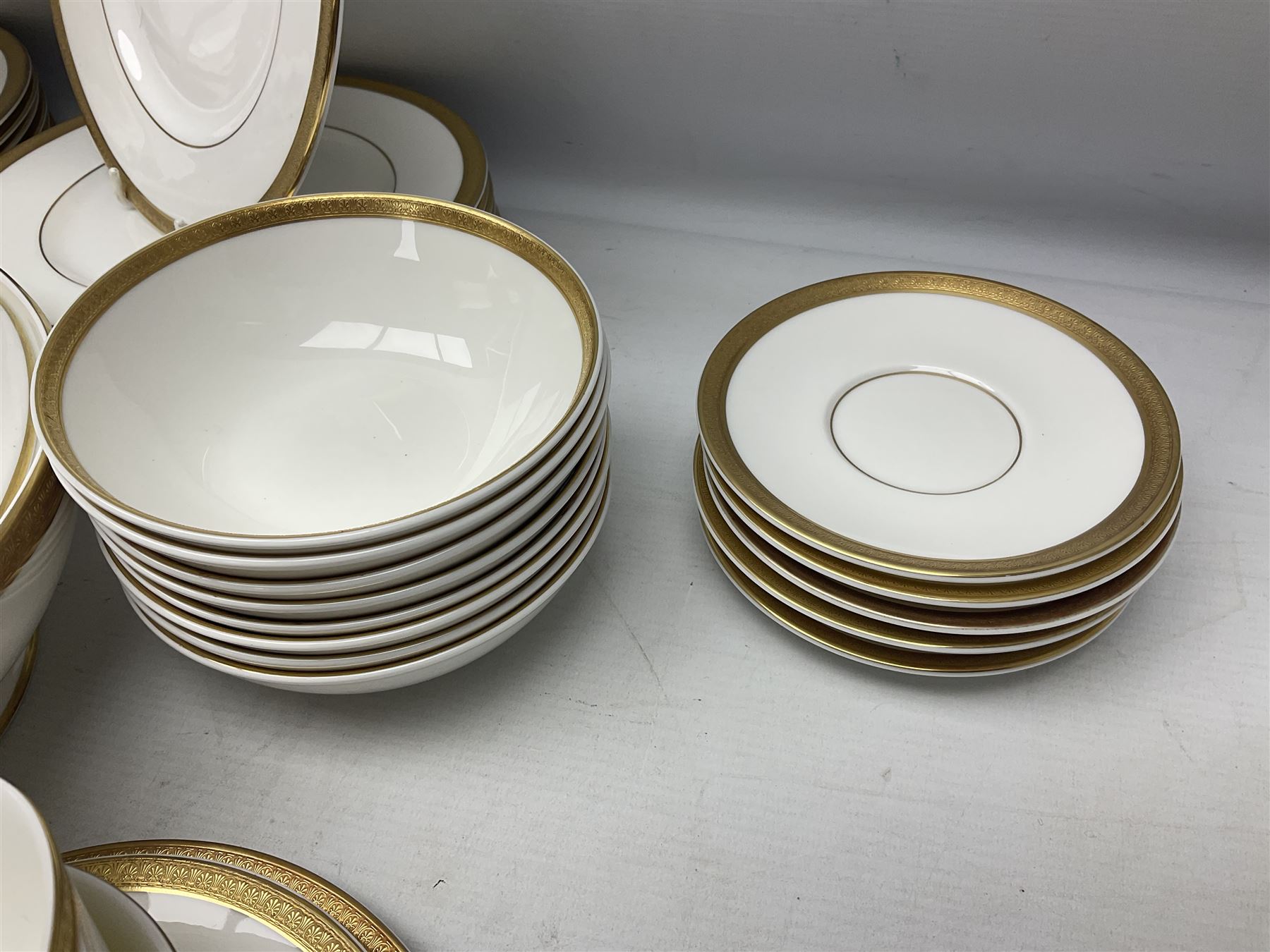 Royal Doulton Royal Gold pattern tea and dinner service for eight, comprising dinner plates, side plates, tea plates, soup bowls, sauce boat and saucer, dessert bowls, coffee cans and saucers, teacups and saucers and two lidded tureens
