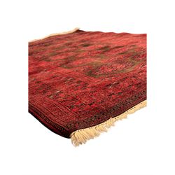 Turkoman red ground wool rug, the field with a repeating pattern of Tekke gul motifs in dark brown and red (195cm x 98cm); Afghan Bokhara red ground wool rug, central field with repeated geometric octagonal gul motifs, surrounded by multiple borders with stylised diamond and triangular patterns (127cm x 181cm)