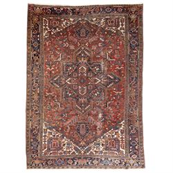 Persian Heriz carpet, red ground with large central geometric medallion, angular flowering...