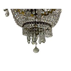 Empire design brass and crystal chandelier, the two circular brass tiers with foliate mounts, connecting the cascading crystal garlands, with prismatic drops